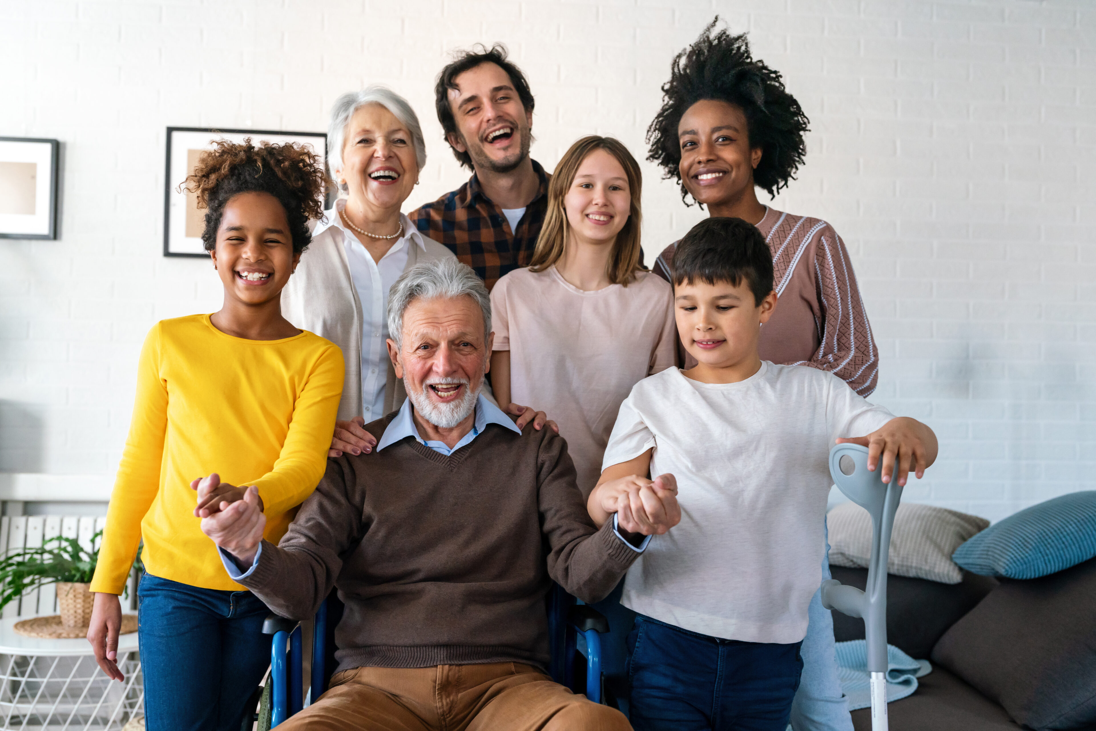 Multi generation, multiethnic family at home together, grandfather with disability. Family happiness concept.